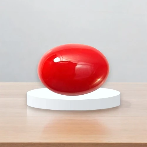 Red Coral (Moonga) stone on podium on table